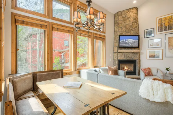 a living room with furniture a fireplace and large windows
