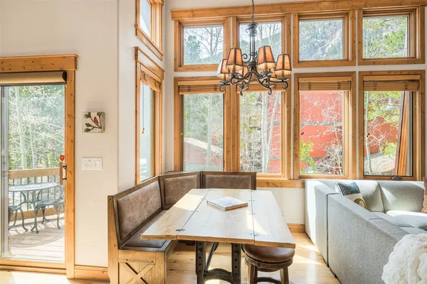 a view of a dining room with furniture large windows and a chandelier