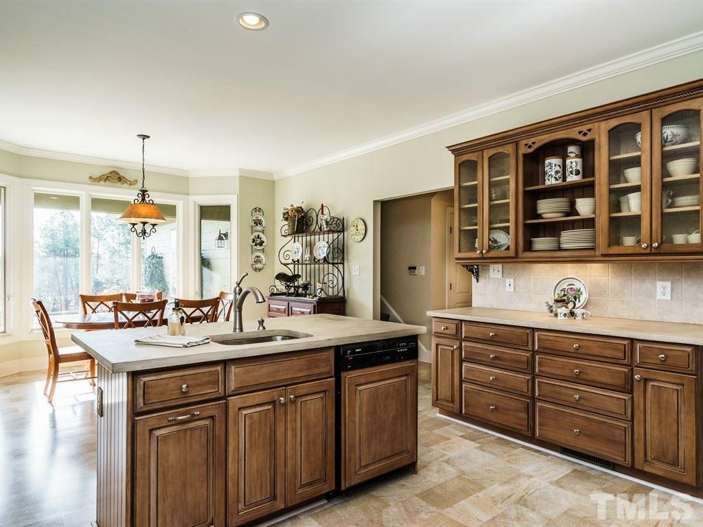 2125 Olive Chapel Road Apex, NC 27502 - Photo 9 of 25 Kitchen and breakfast room looking out to the veranda and expansive view beyond.