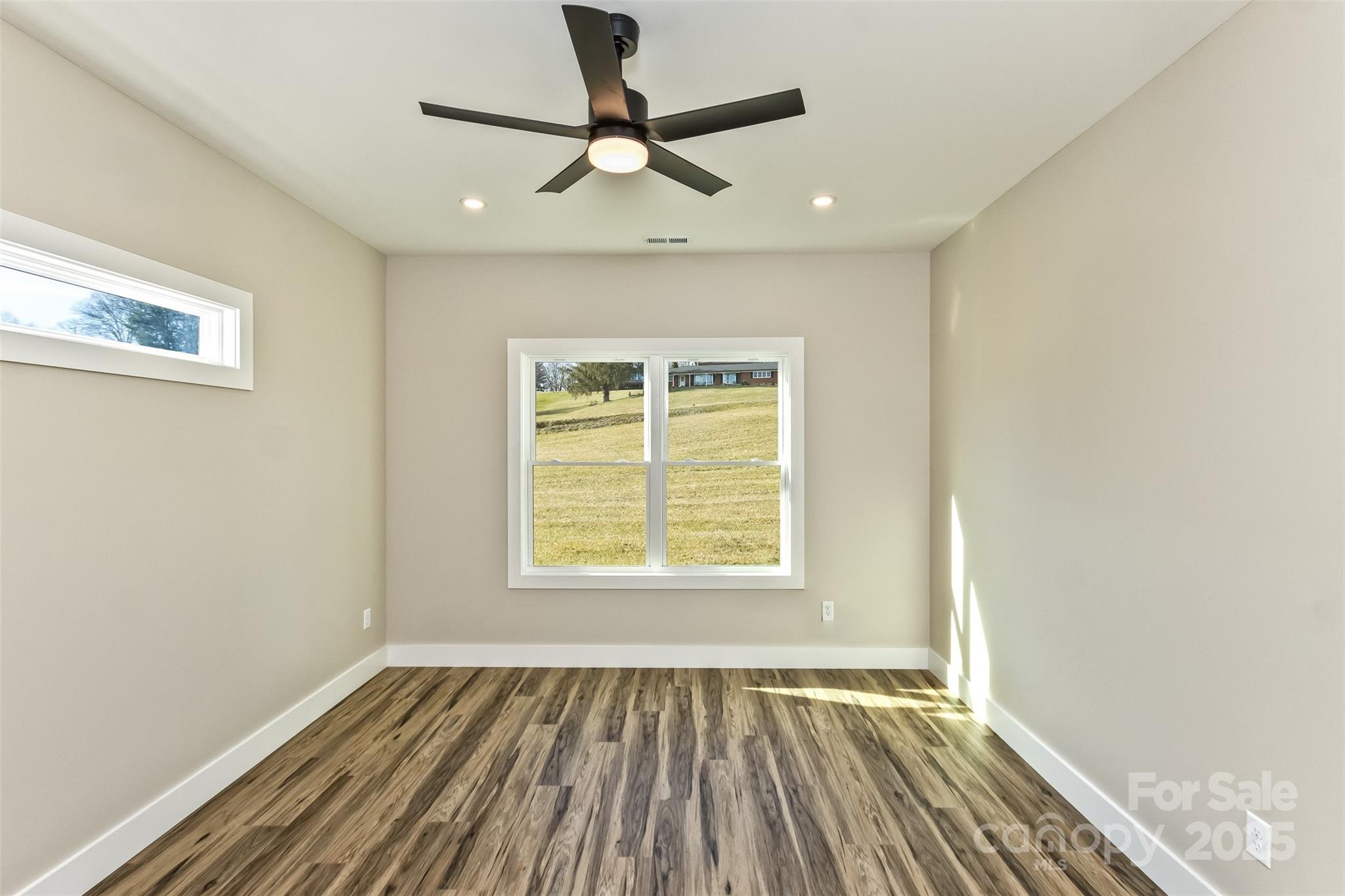 115 Peyton Elaine Road Clyde, NC 28721 - Photo 15 of 37 a view of an empty room with wooden floor and a window