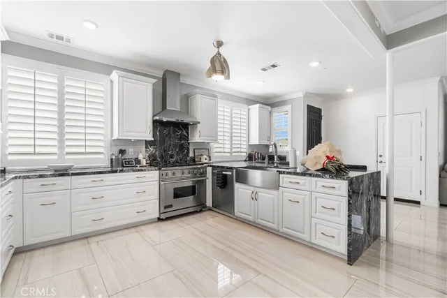 a kitchen with granite countertop a refrigerator and a stove top oven