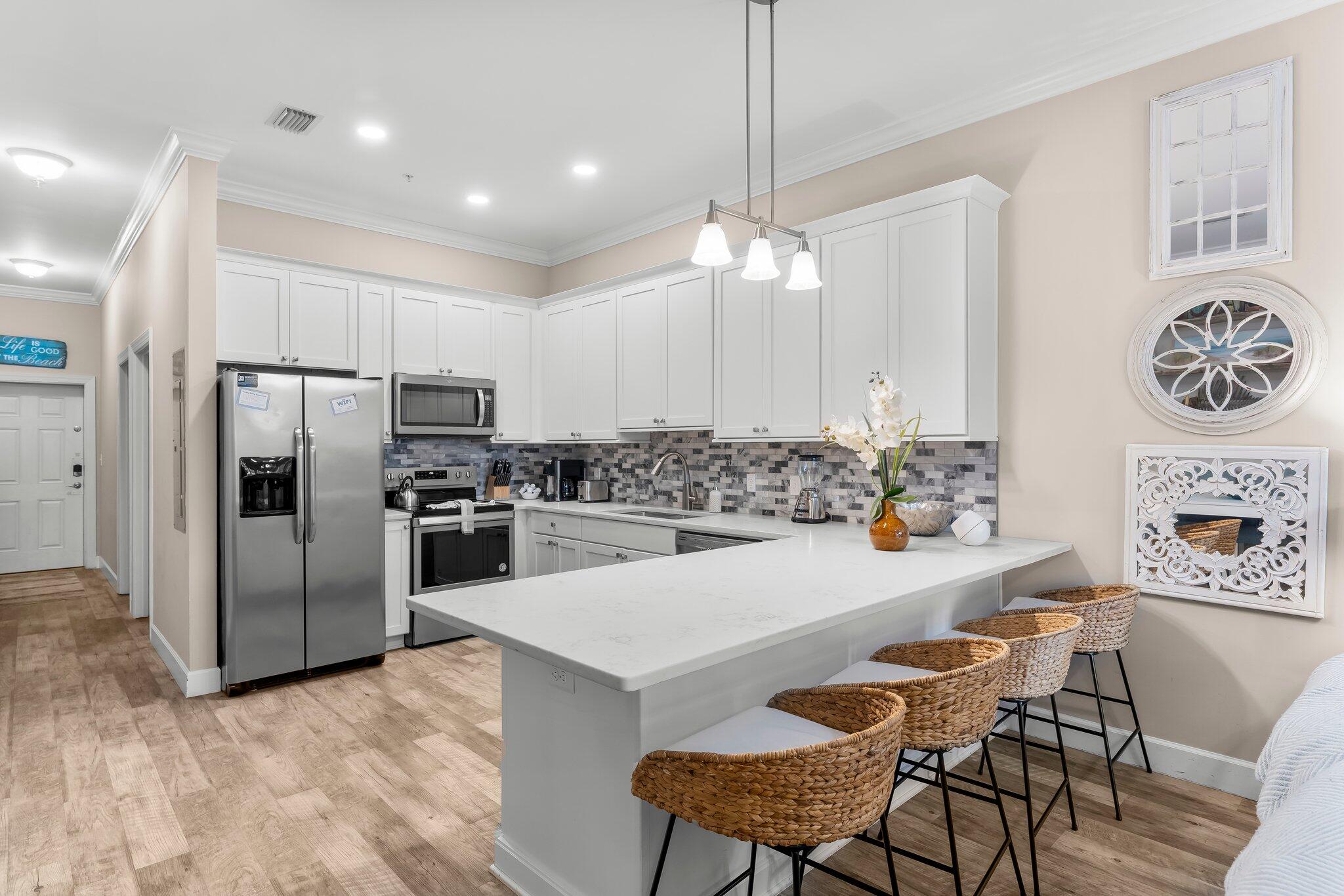 231 Somerset Bridge Road, Unit 2209 Santa Rosa Beach, FL 32459 - Photo 5 of 30 a kitchen with stainless steel appliances a refrigerator a stove a table and chairs