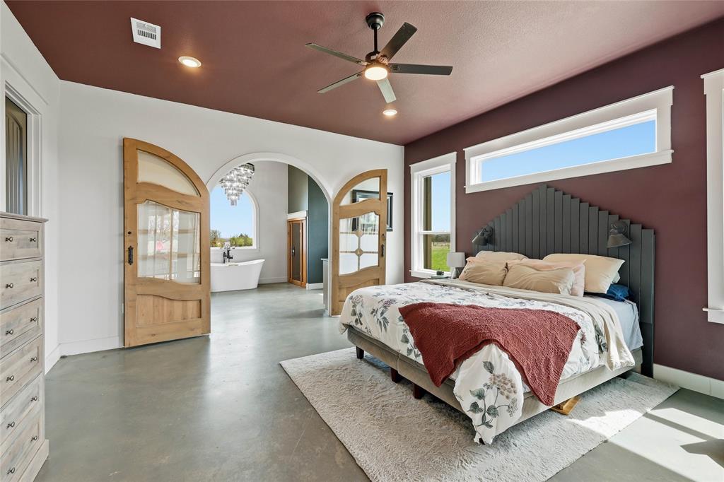 3988 Lake Valley Road Sunset, TX 76270 - Photo 15 of 39 a spacious bedroom with a large bed and ceiling fan
