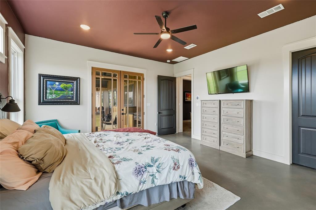 3988 Lake Valley Road Sunset, TX 76270 - Photo 16 of 39 a bedroom with a large bed a flat tv screen and dresser