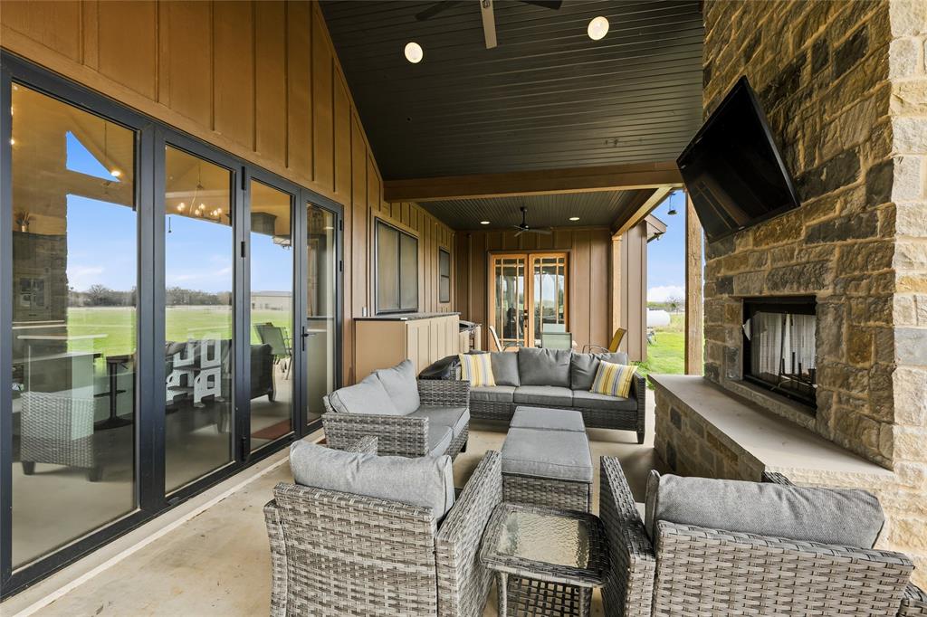 3988 Lake Valley Road Sunset, TX 76270 - Photo 29 of 39 a living room with furniture a fireplace and a floor to ceiling window