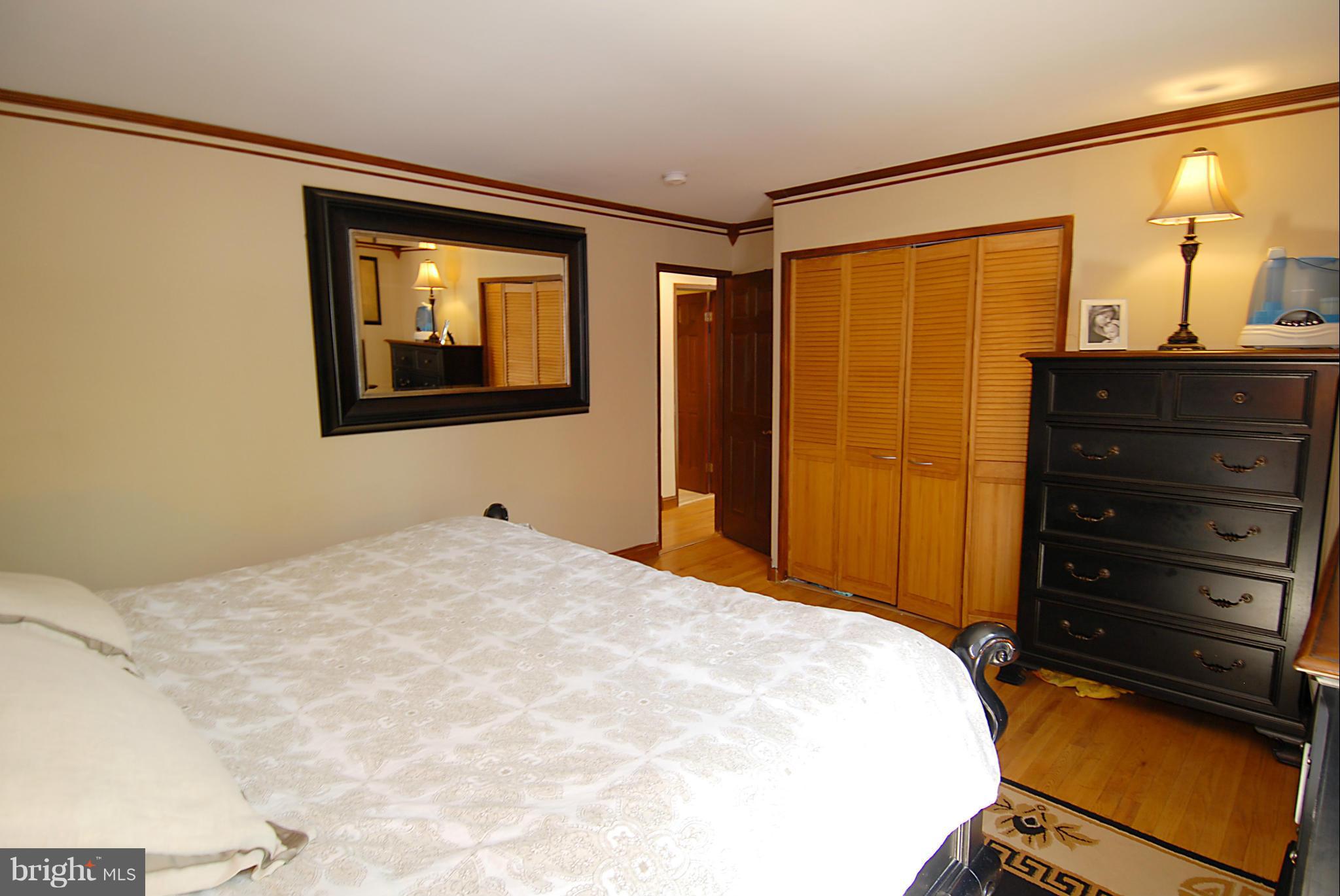 11502 Hickory Cluster Reston, VA 20190 - Photo 22 of 29 a bedroom with a bed and a mirror