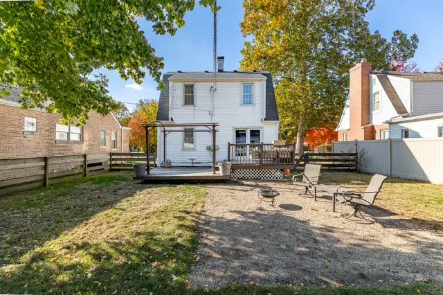 a view of backyard of house with wooden floor and fence