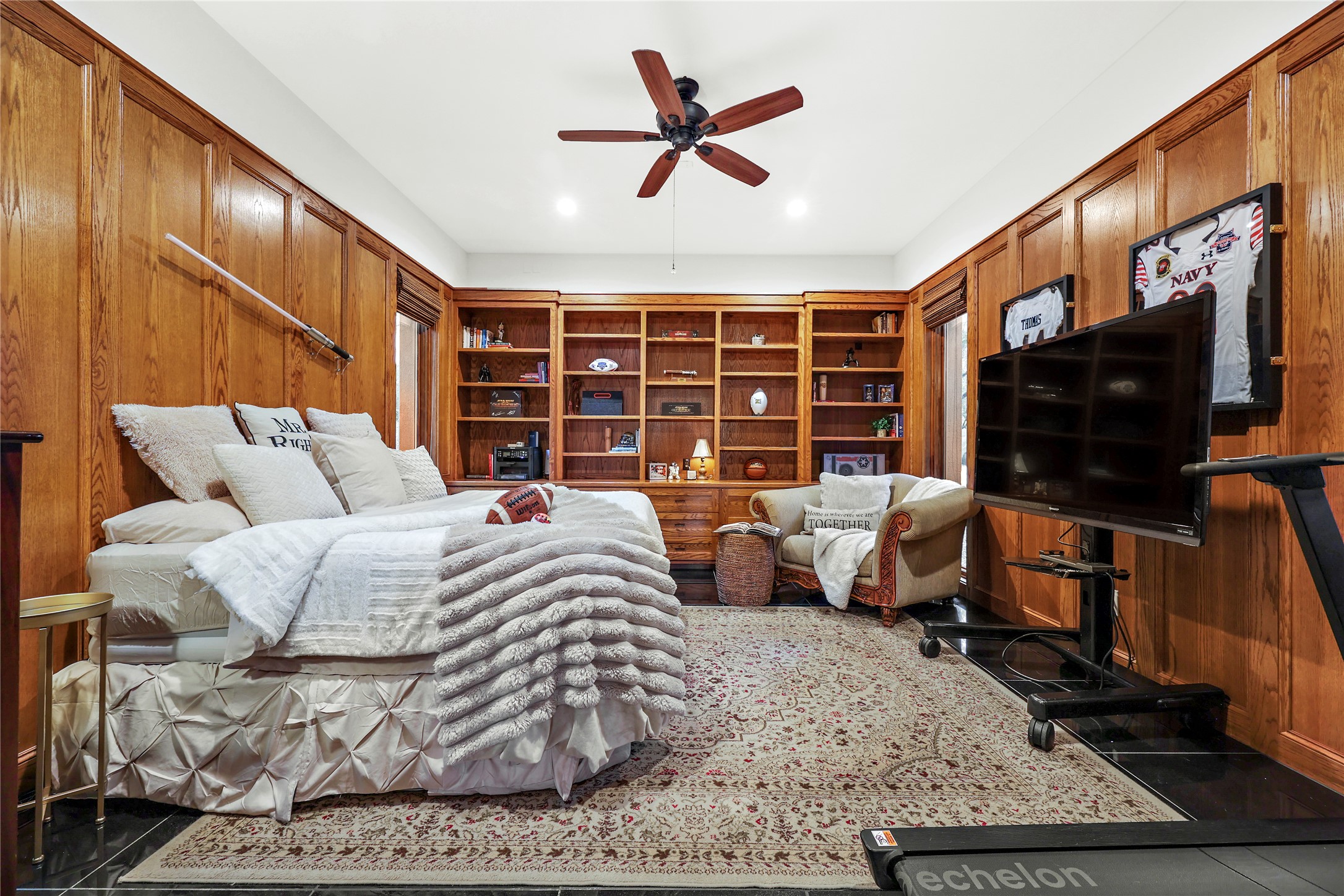 17501 Navigation Lane Lago Vista, TX 78645 - Photo 26 of 40 This versatile downstairs bedroom/office/flex room features wood paneling, extensive built-in shelving, and dark tile flooring