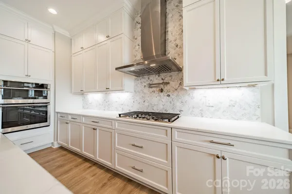 a kitchen with stainless steel appliances white cabinets and a stove