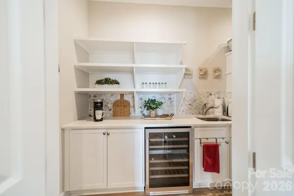 a view of cabinets a oven and a potted plant on a dresser