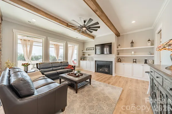 a living room with furniture a fireplace and a large window