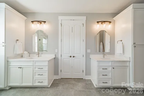 a spacious bathroom with a double vanity sink and a mirror