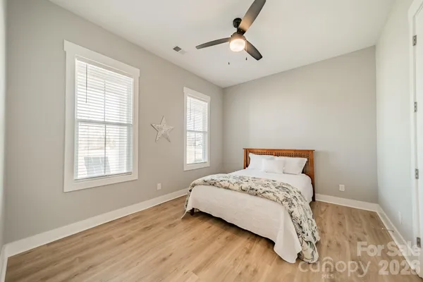 a bedroom with a bed and wooden floor