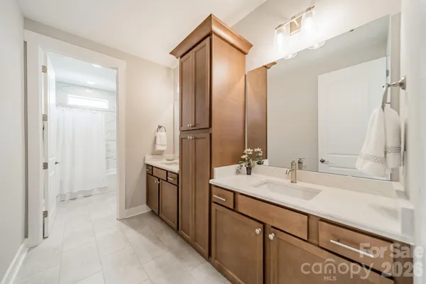 a bathroom with a double vanity sink mirror and shower