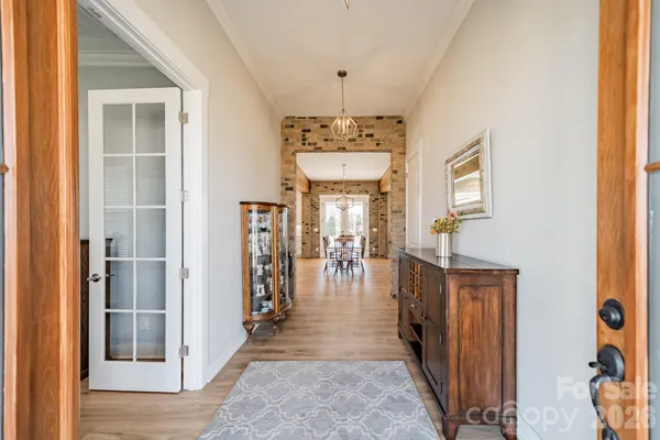 a hallway with wooden floor closet and living room