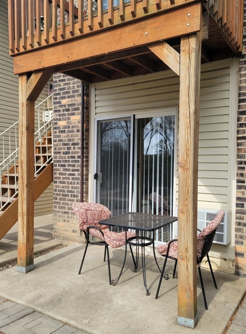 2700 Light Road, Unit 110 Oswego, IL 60543 - Photo 8 of 12 a brick building with a bench and a chair