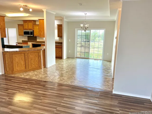 a view of a kitchen with kitchen island wooden floor and stainless steel appliances