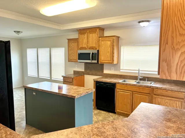 a kitchen with granite countertop a sink and a stove top oven