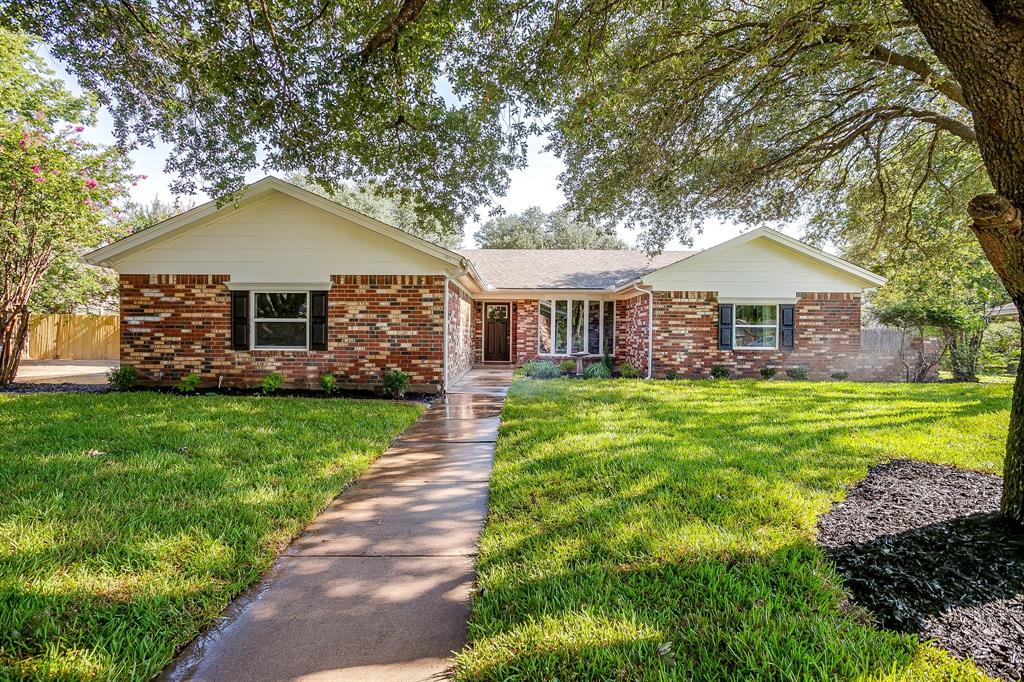 a front view of a house with a garden and yard