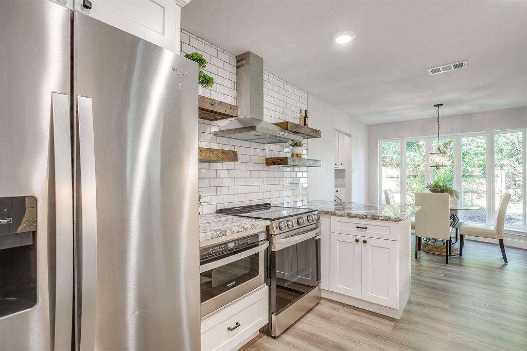 1003 Canton Road Cleburne, TX 76033 - Photo 13 of 40 a kitchen with stainless steel appliances granite countertop a stove and a refrigerator