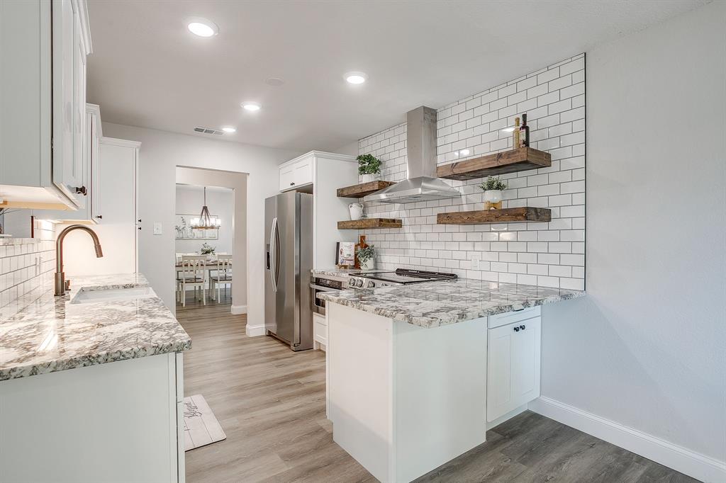 1003 Canton Road Cleburne, TX 76033 - Photo 14 of 40 a kitchen with granite countertop a sink stainless steel appliances and cabinets