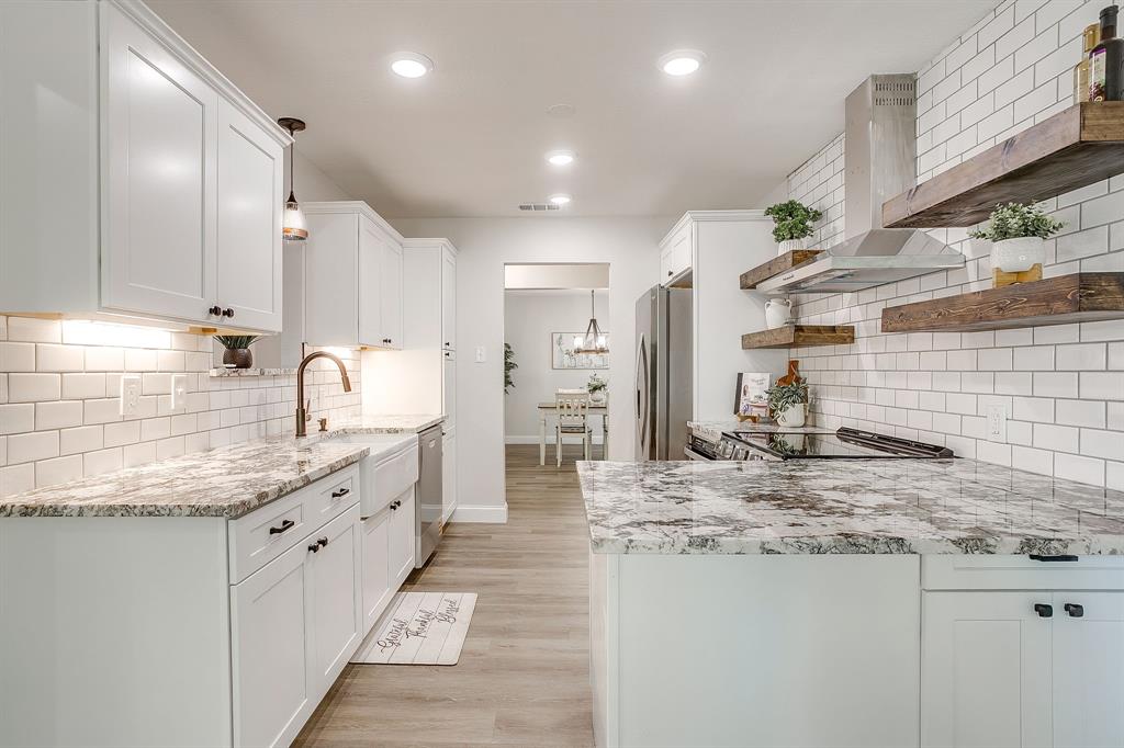 1003 Canton Road Cleburne, TX 76033 - Photo 15 of 40 a kitchen with kitchen island granite countertop a sink a counter space appliances and cabinets