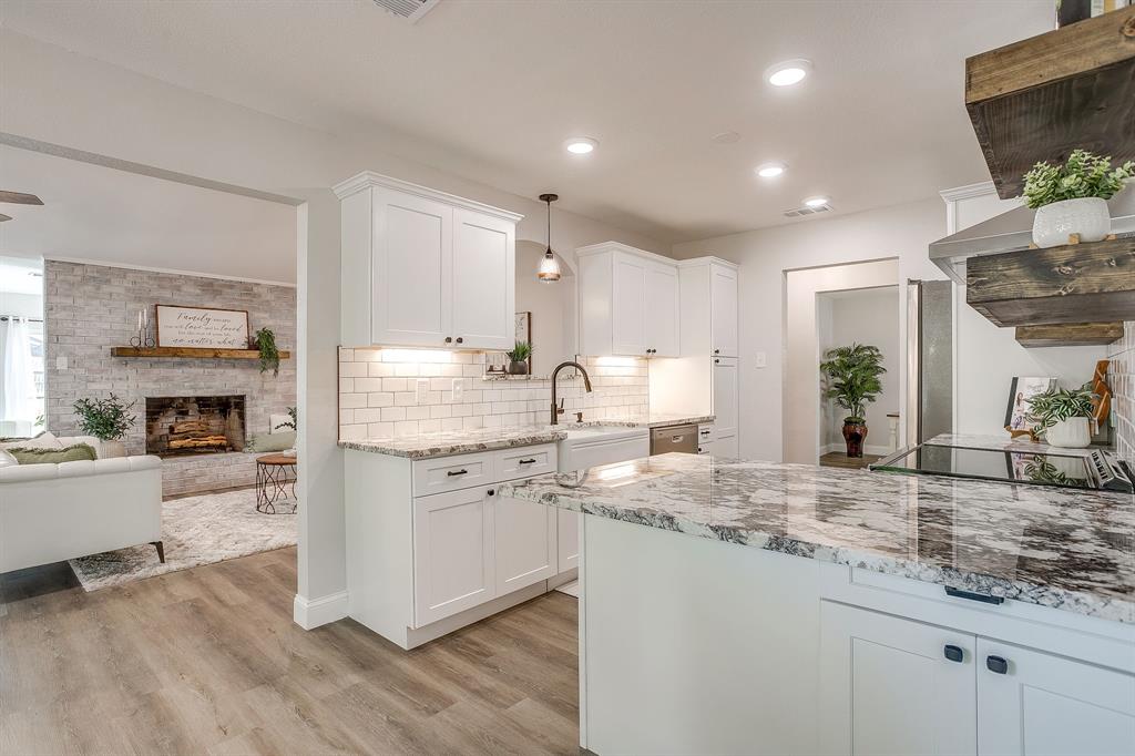 1003 Canton Road Cleburne, TX 76033 - Photo 16 of 40 a kitchen with kitchen island granite countertop a sink cabinets and wooden floor