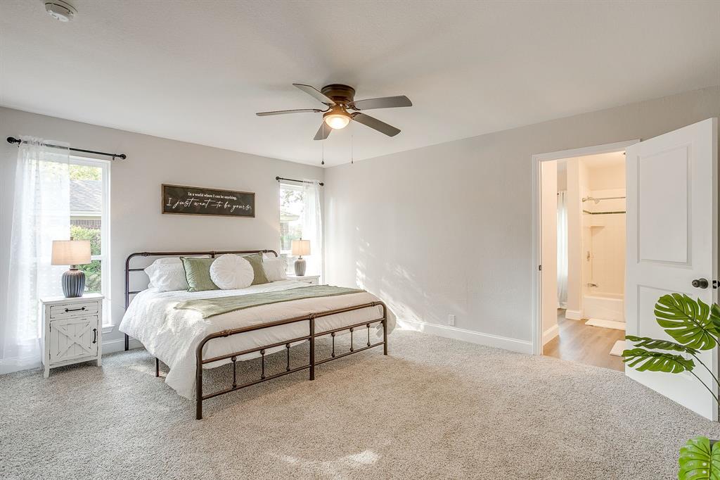 1003 Canton Road Cleburne, TX 76033 - Photo 19 of 40 a spacious bedroom with a bed and a chandelier