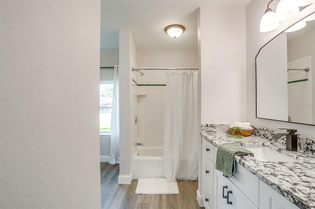 1003 Canton Road Cleburne, TX 76033 - Photo 22 of 40 a bathroom with a sink and a mirror