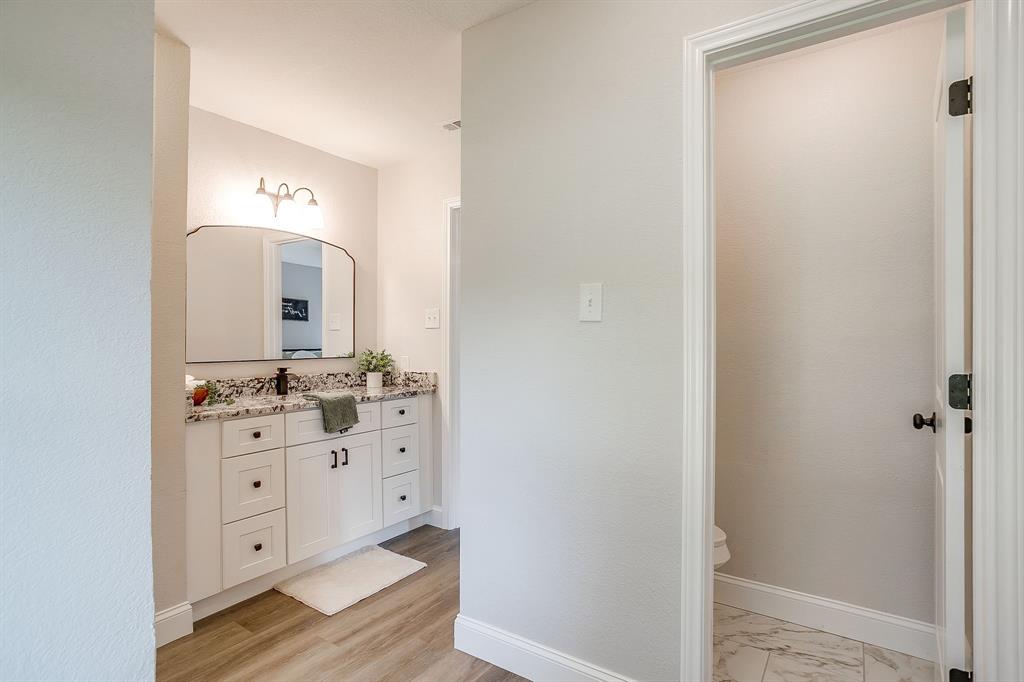 1003 Canton Road Cleburne, TX 76033 - Photo 23 of 40 a spacious bathroom with a double vanity sink and mirror