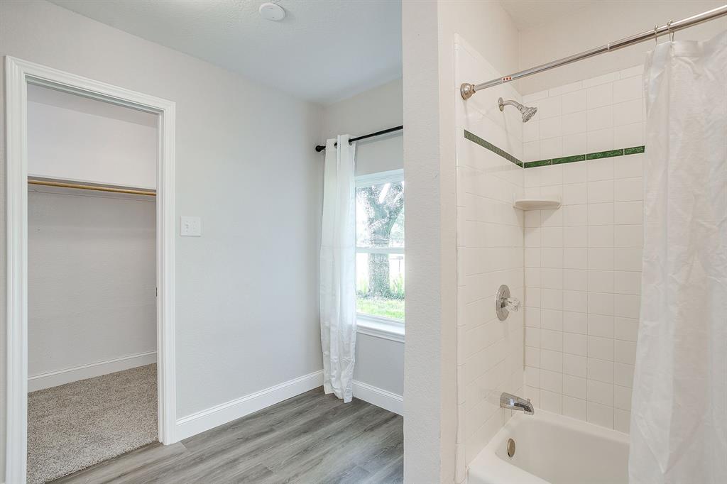 1003 Canton Road Cleburne, TX 76033 - Photo 24 of 40 a bathroom with a bathtub shower and a sink