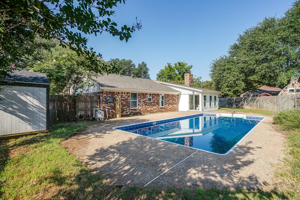 1003 Canton Road Cleburne, TX 76033 - Photo 32 of 40 a front view of house with yard swimming pool and trees in the background