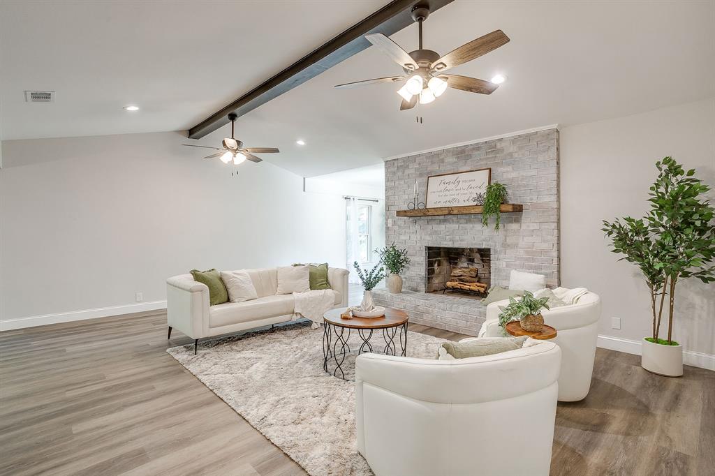 1003 Canton Road Cleburne, TX 76033 - Photo 5 of 40 a living room with furniture a chandelier and a fireplace