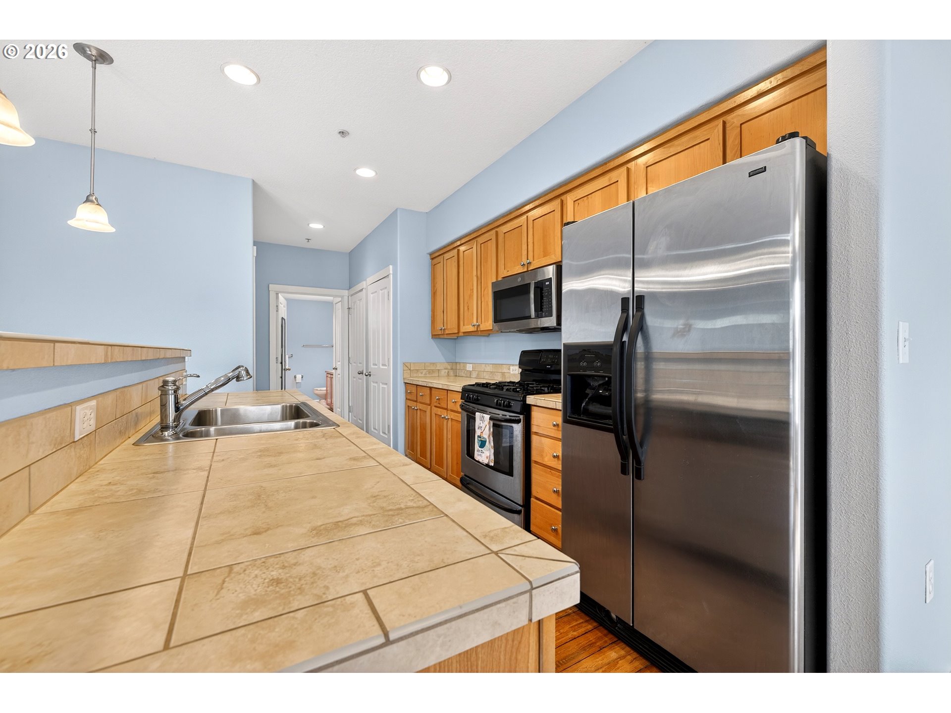 102 Northeast Canvasback Way Hillsboro, OR 97006 - Photo 12 of 36 a kitchen with stainless steel appliances kitchen island granite countertop a refrigerator and microwave