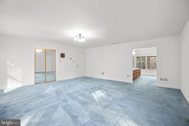 an empty room with windows and closet