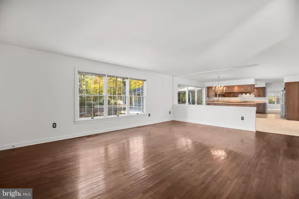 a kitchen with kitchen island granite countertop a refrigerator a sink dishwasher a oven and a dining table with wooden floor