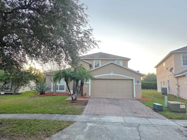 a front view of a house with a yard and a garage