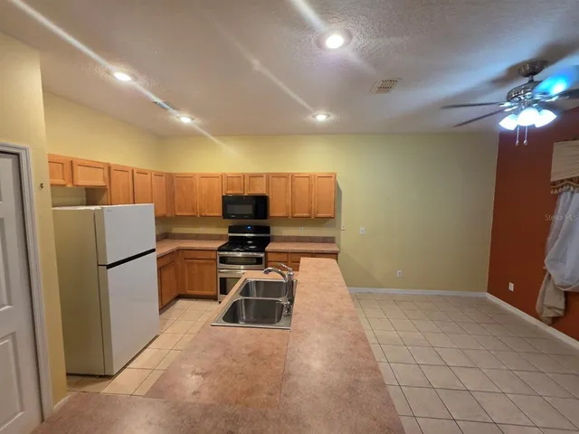 a kitchen with stainless steel appliances a refrigerator and a stove top oven