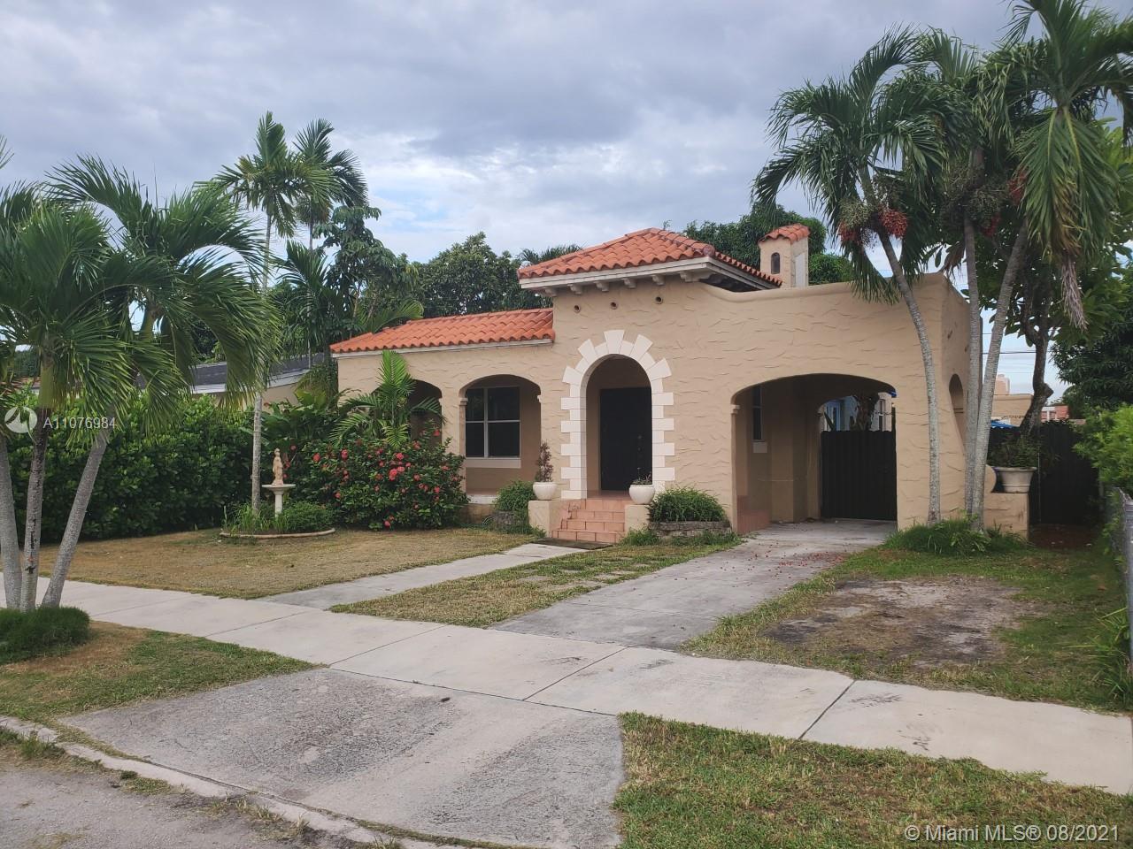 a view of white house with a yard and palm trees