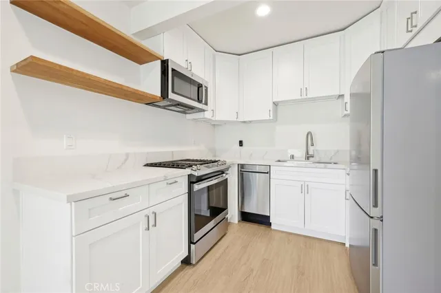 a kitchen with stainless steel appliances a refrigerator stove and microwave