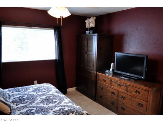 152 Cypress Way East, Unit 7 Naples, FL 34110 - Photo 11 of 21 a bedroom with a bed and a flat screen tv