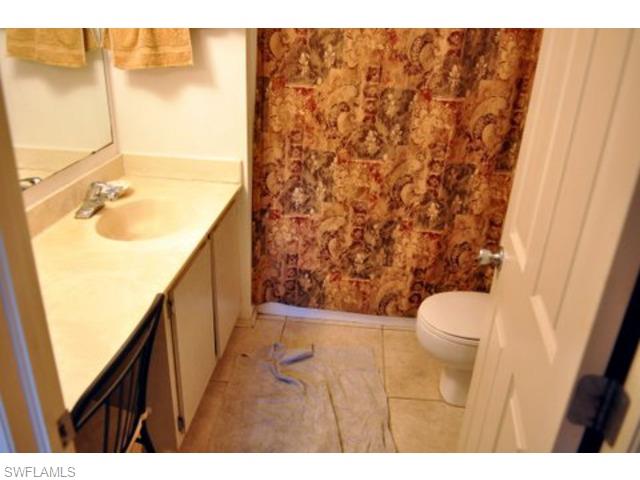 152 Cypress Way East, Unit 7 Naples, FL 34110 - Photo 12 of 21 a bathroom with a sink and a toilet