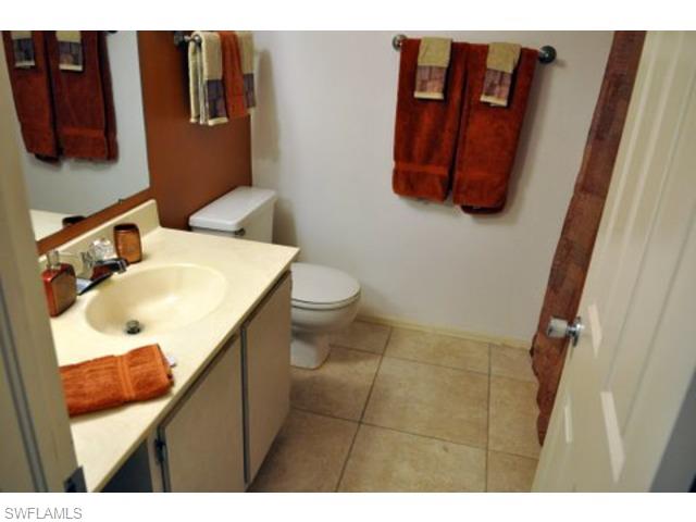 152 Cypress Way East, Unit 7 Naples, FL 34110 - Photo 15 of 21 a bathroom with a toilet sink and mirror