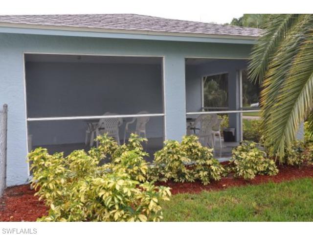 152 Cypress Way East, Unit 7 Naples, FL 34110 - Photo 18 of 21 a front view of a house with a yard