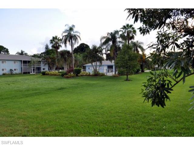 152 Cypress Way East, Unit 7 Naples, FL 34110 - Photo 19 of 21 a backyard of a house with table and chairs