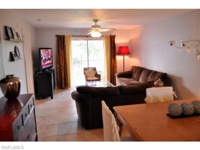 152 Cypress Way East, Unit 7 Naples, FL 34110 - Photo 5 of 21 a living room with furniture and a flat screen tv