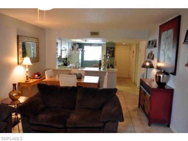 152 Cypress Way East, Unit 7 Naples, FL 34110 - Photo 6 of 21 a living room with furniture window and wooden floor
