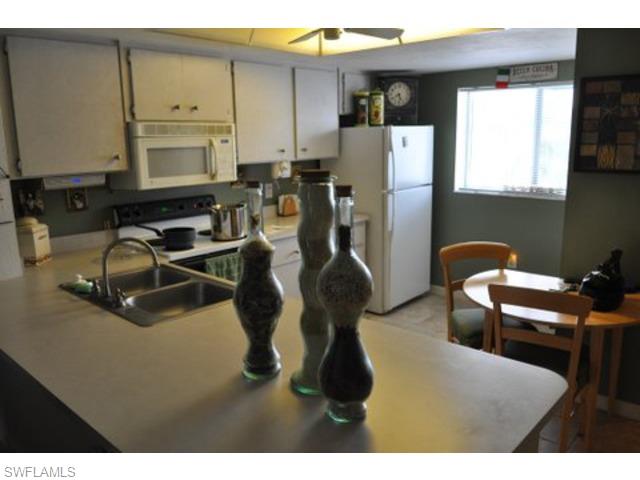 152 Cypress Way East, Unit 7 Naples, FL 34110 - Photo 7 of 21 a room with furniture a window and kitchen