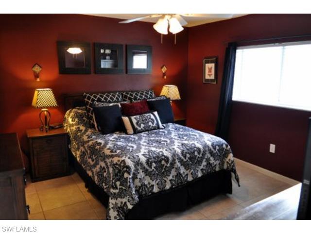 152 Cypress Way East, Unit 7 Naples, FL 34110 - Photo 10 of 21 a bed sitting in a bedroom next to a window