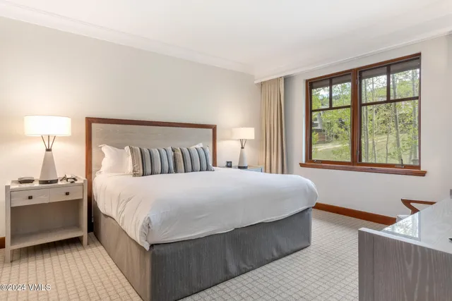 a bedroom with a large bed and a window